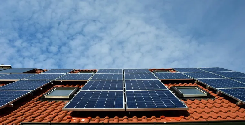 Solarmodule auf einem Ziegeldach von unten fotografiert